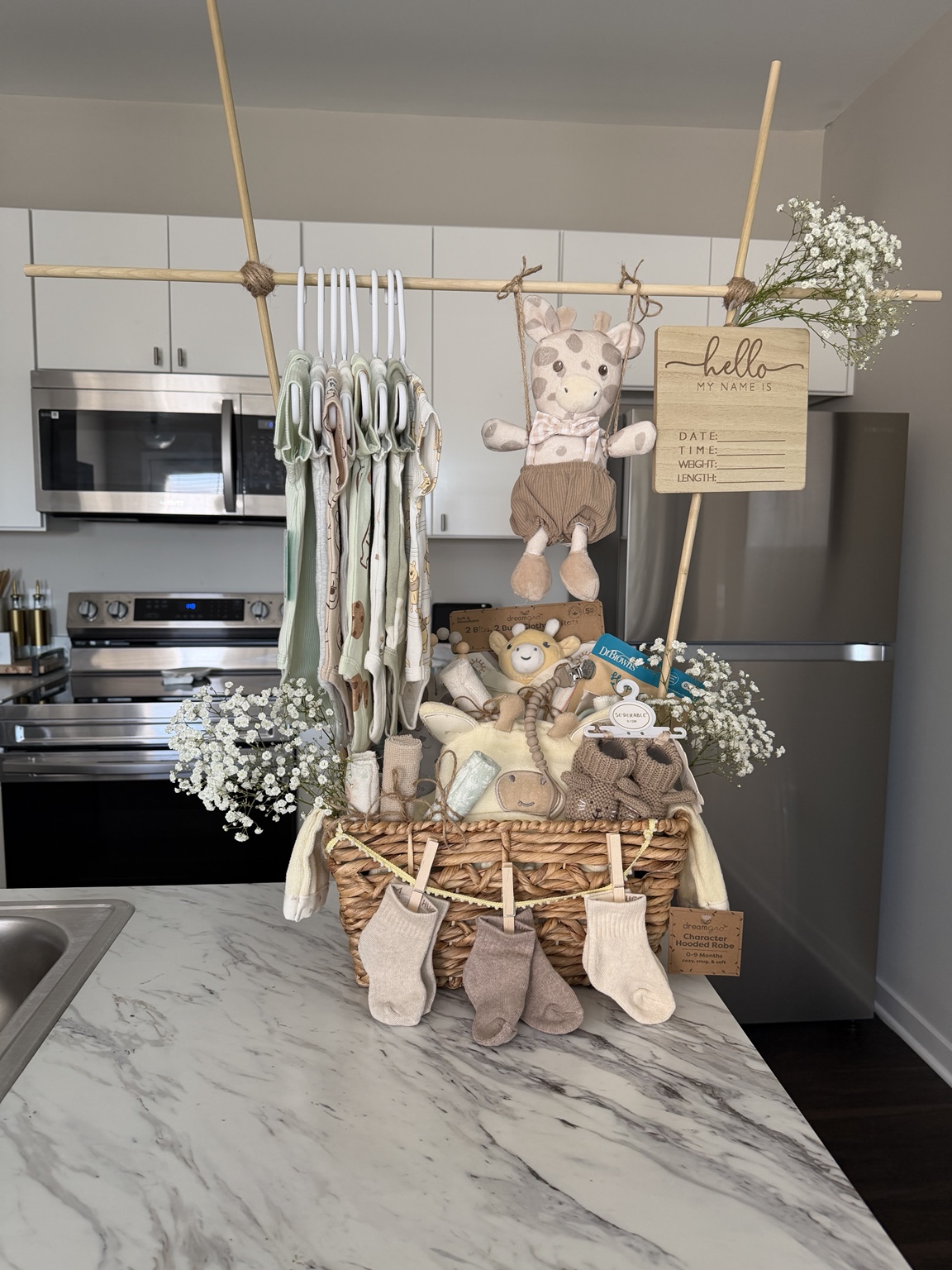 Custom neutral baby shower centerpiece with hanging keepsakes and delicate flowers