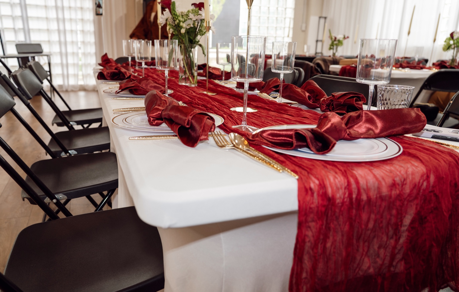 Burgundy napkins and runner on a white celebration table