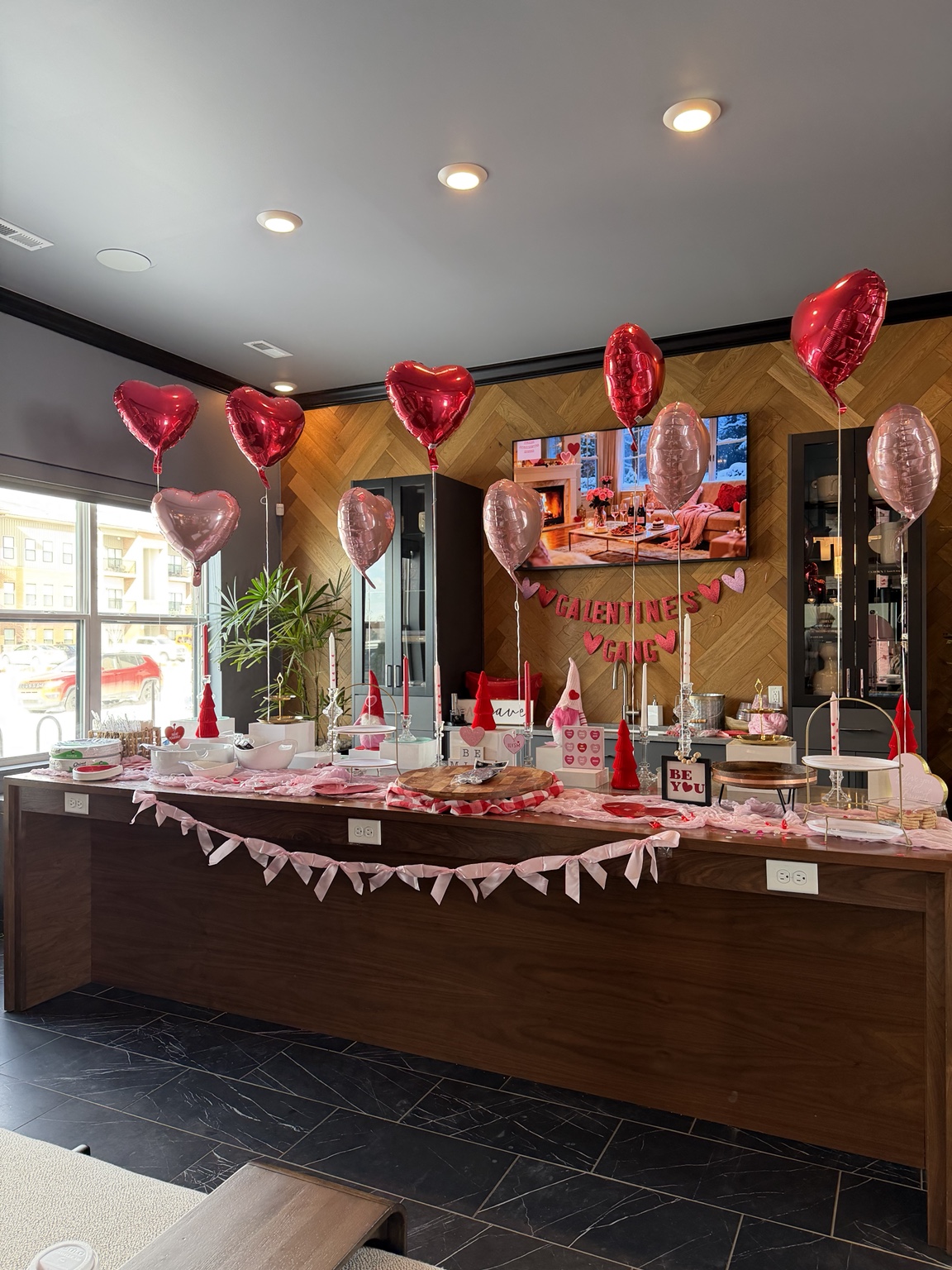 Valentine celebration table with heart balloons, flowers, and personalized details